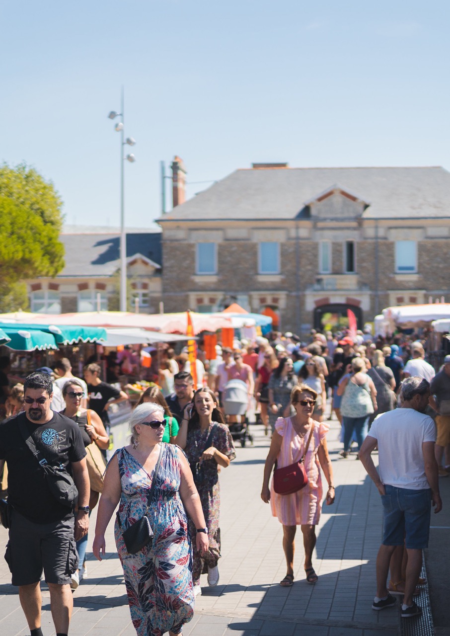 Passants entre les étals du marché
