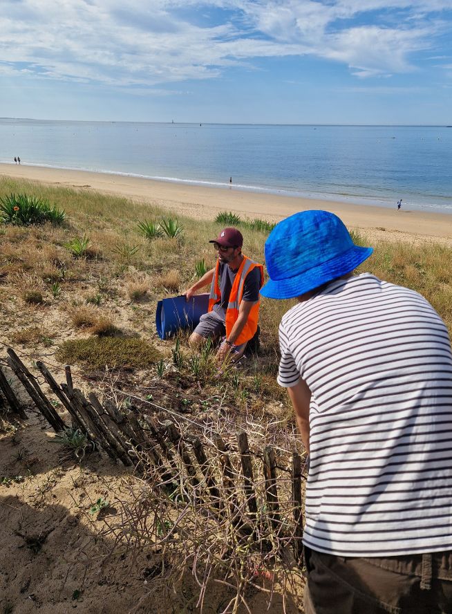 Enfant écoutant un expert au service de la gestion des dunes
